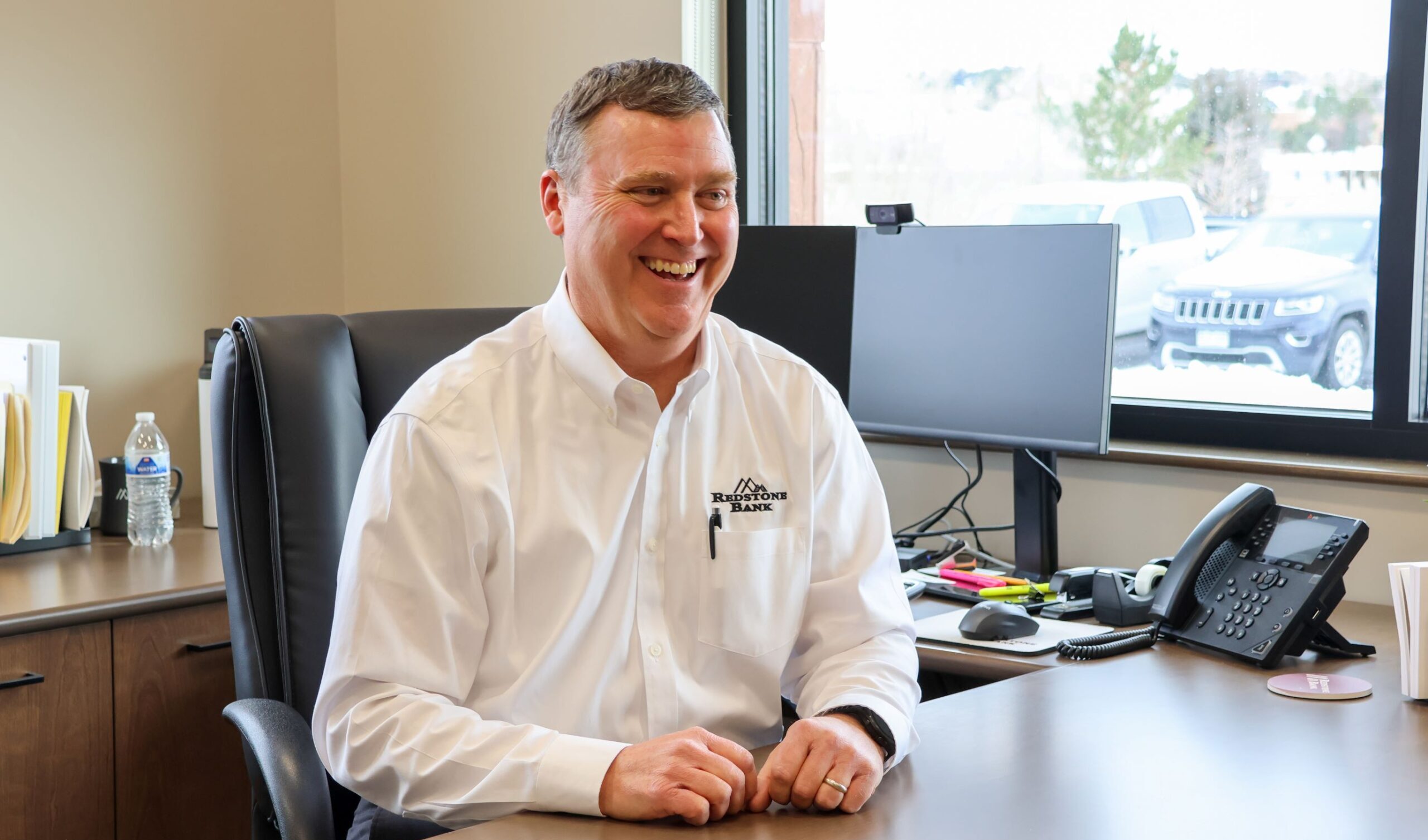 Jason Whyte, treasury management officer smiling as he sits as his desk
