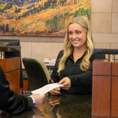 Jessica from the Centennial branch handing a deposit slip receipt to a customer.