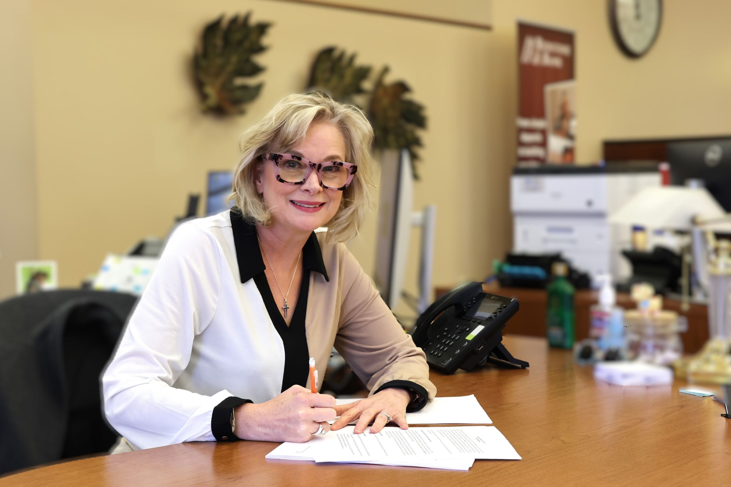 Shannon, loan administrator at our Littleton branch sitting at her desk smiling at the camera