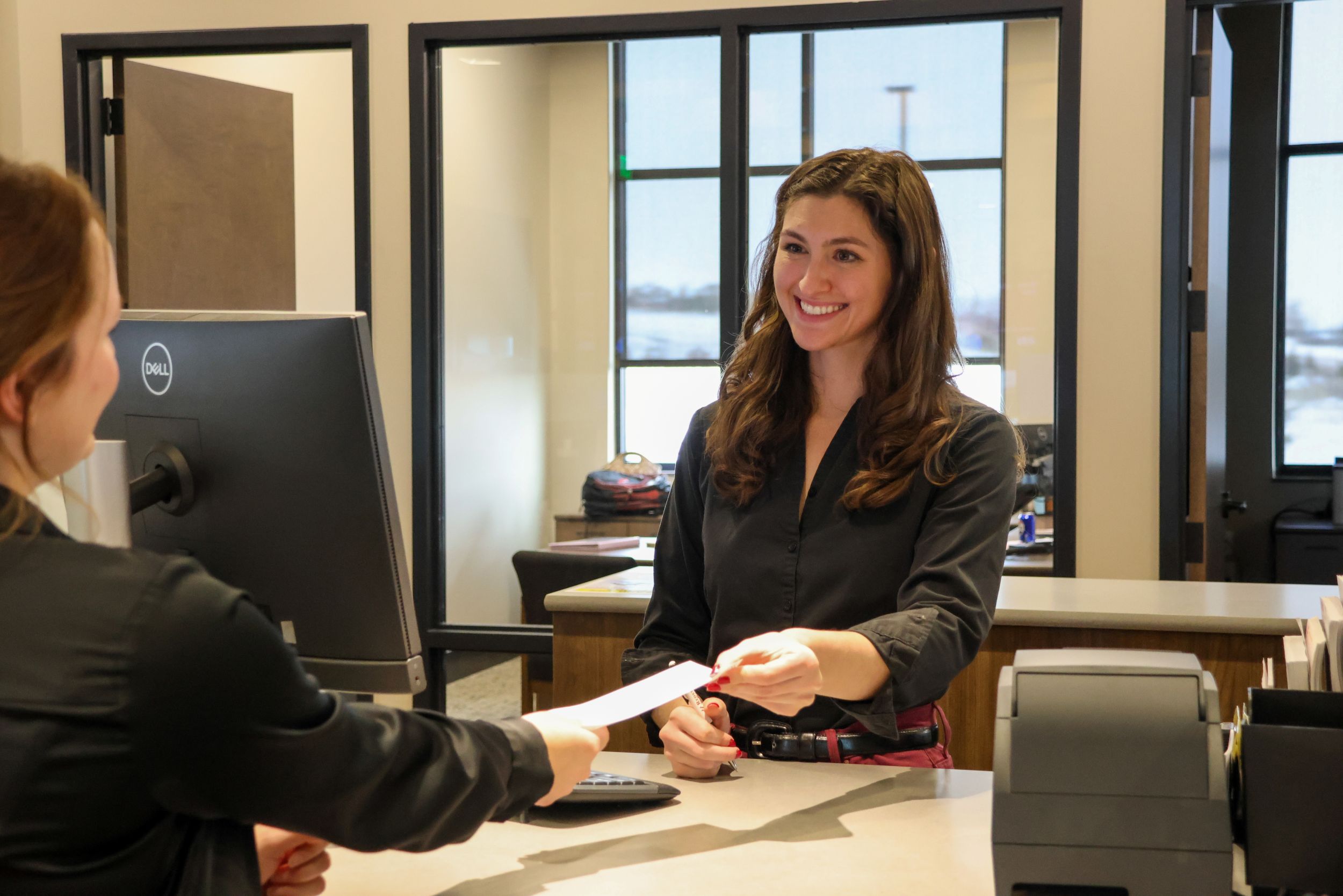 Madison, retail banking manager helping a client at the teller line in Parker.